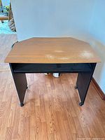 Front view showing brown laminate top, black legs, shelf and casters