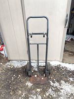 Front view of steel hand truck showing frame, toe plate, main wheels