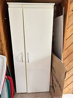 Closed view of tall white two-door cabinet