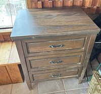 Closed sewing stand showing three front panels and top surface finish