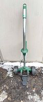 Full view of wheeled pot mover showing handle, frame, wheels, foot plate