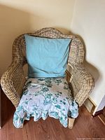 Front view of wicker armchair with pillow and cushion