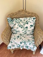 Front view of wicker armchair with cushion and pillow
