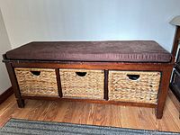 Front view of bench showing three wicker drawers and cushion