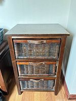 Front view of wood frame organizer with three wicker drawers