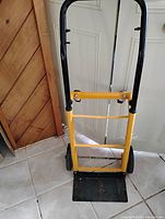 Front view of yellow and black hand truck standing upright