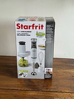 Box front showing Starfrit 4-in-1 Hand Blender set and attachments