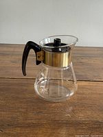 Front view of glass coffee pot showing handle, lid, collar, star pattern