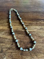 Full view of entire beaded necklace laid flat on wood surface