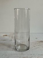 Full view of clear cylindrical glass vase upright