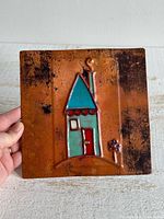 Full view of square copper plaque with enamel house design