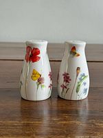Front view of both shakers showing floral and butterfly prints