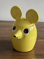 Front angled view of yellow mouse cookie jar with lid on