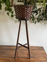Full view of wooden tripod planter stand with basket