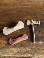 Two birch bark canoes and wooden tomahawk on wooden surface