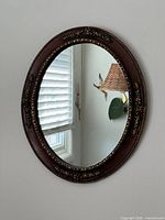 Full view oval wall mirror on wall