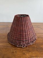 Side view of conical wicker lamp shade showing woven pattern and lower leather trim