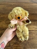 Front view of golden Merrythought teddy bear with ribbon bow, showing overall appearance