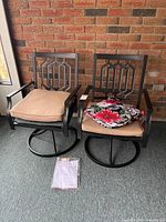 Two assembled PHI VILLA swivel chairs with tan cushions, extra floral cushion and hardware packet visible