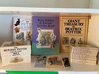 Overview of books, slip-case, sticker book, activity book, treasury, postcards, buttons