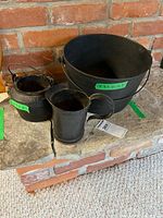 Group shot of all four black metal containers on stone hearth