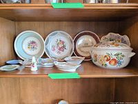 Shelf view showing tureen, plates, reticulated dishes, bell