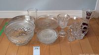 Group shot of all clear glass items, red holders and tray