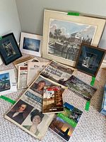 Overview of lot showing framed artworks, books, newspapers and ephemera