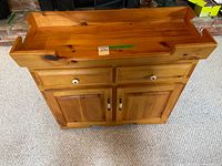 Front view showing raised rim top, drawers, cabinet doors