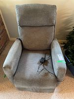 Front view of gray fabric electric recliner showing overall design and included power adapter