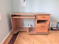 Full frontal view of the wood-laminate computer desk on casters