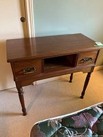 full view of wooden desk with two drawers, open center shelf, turned legs