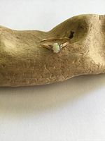 Front view of gold ring showing opal center and diamond chips