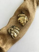 Front view of both gilt silver lockets showing female head motifs