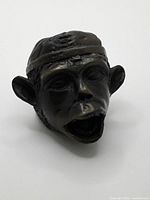 front view of cast metal monkey head ornament