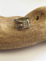 Front view of sterling buckle ring on wood prop