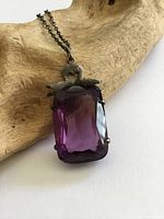 Close-up of pendant showing stone cut, setting, silver bow and chain