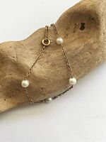 Full bracelet draped on wood showing pearls and chain