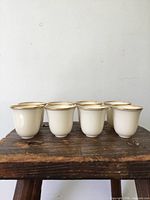 Six cups front view on wooden surface highlighting rim and body