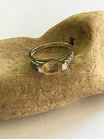 Top view showing yellow center stone, accent stones, hallmark NVC 8