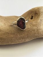 Front view of sterling silver ring on driftwood, showing bezel and glass shard