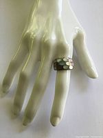 Ring on display hand showing width and mosaic inlay