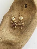 Front view of both gold charms on driftwood showing stones and beaded limbs