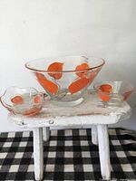 Full view of three-piece glass serving set on stool