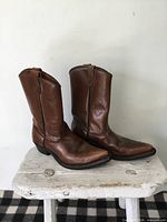 left side view of both boots showing leather uppers, pointed toes, side pull tabs