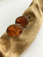 Both amber earrings displayed on wood showing front amber cabochon and silver bezel