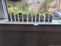 Front view of eleven Delft Blue miniature houses lined on windowsill
