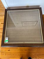 Full view of square coffee table showing glass top, cane insert, wood frame