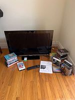 Front view of television with remote, manual and media stacks visible