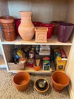 Shelving with terracotta, plastic planters and craft supplies